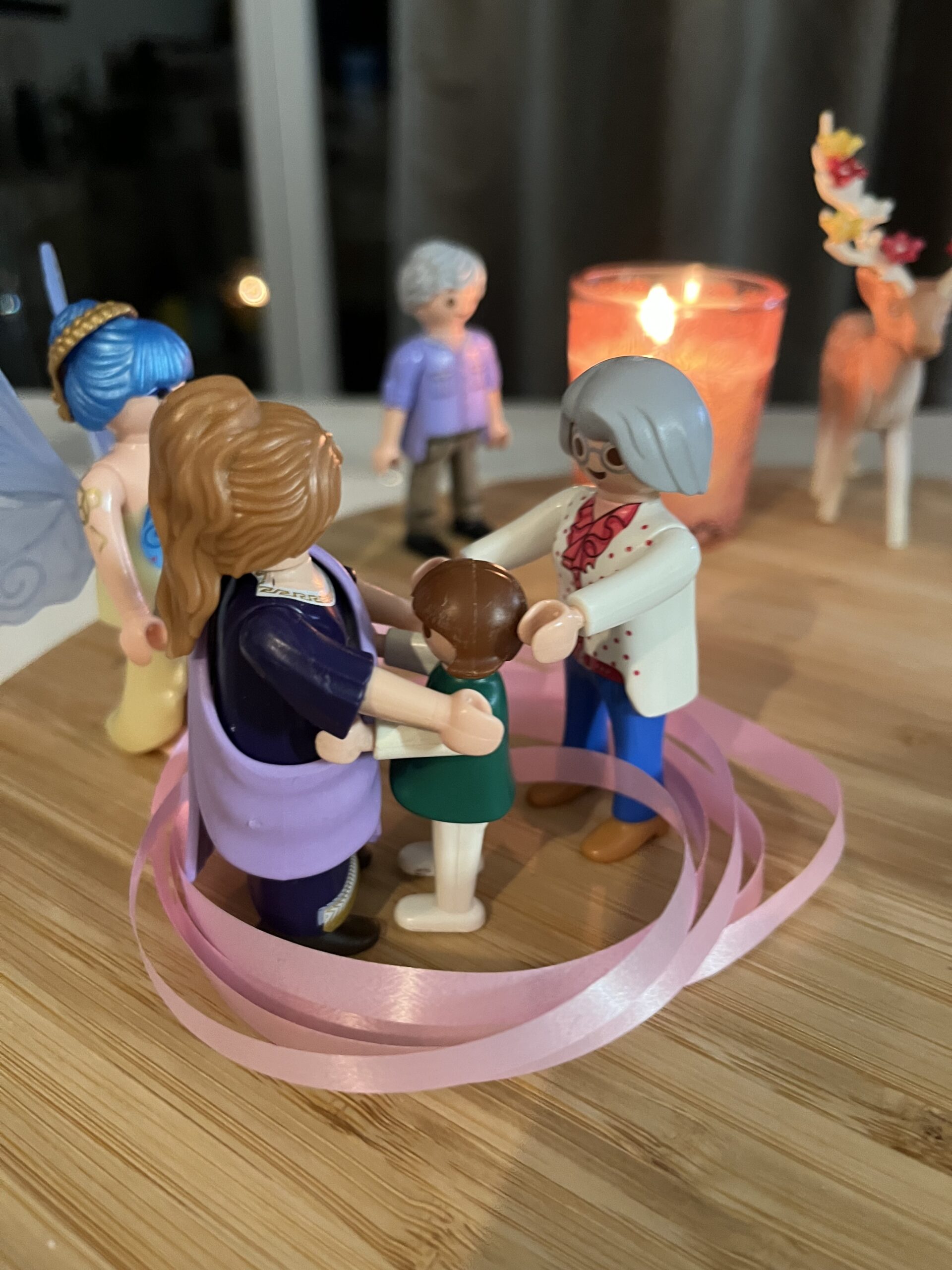 Figurines représentant une constellation familiale individuelle autour d’un ruban rose